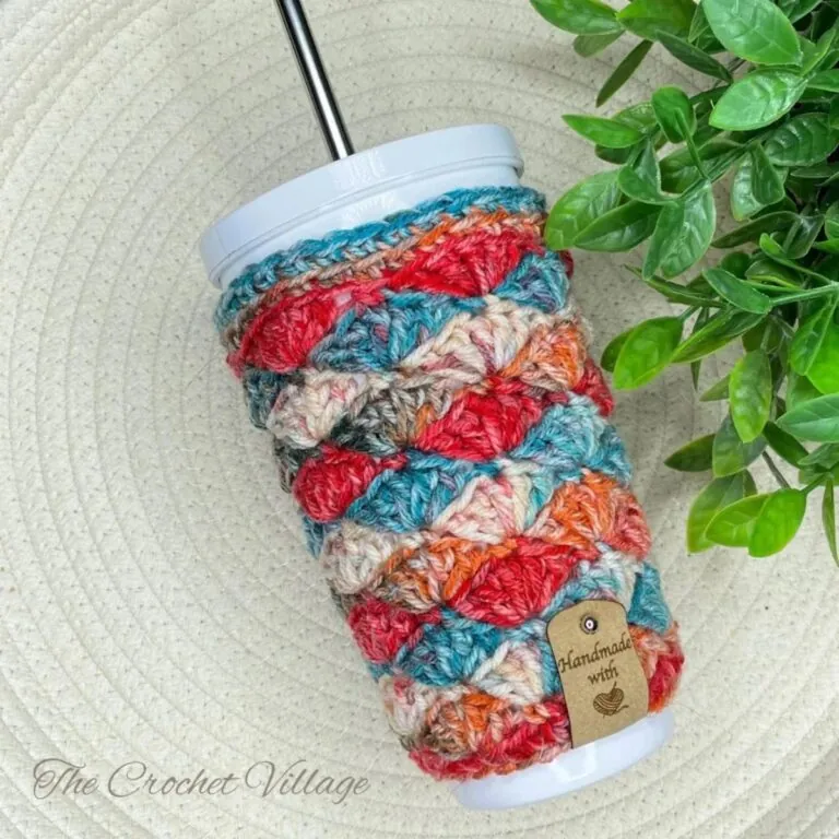 Blossom Cup Cozy crochet pattern in teal, red, and orange variegated shell stitch on a white iced coffee tumbler