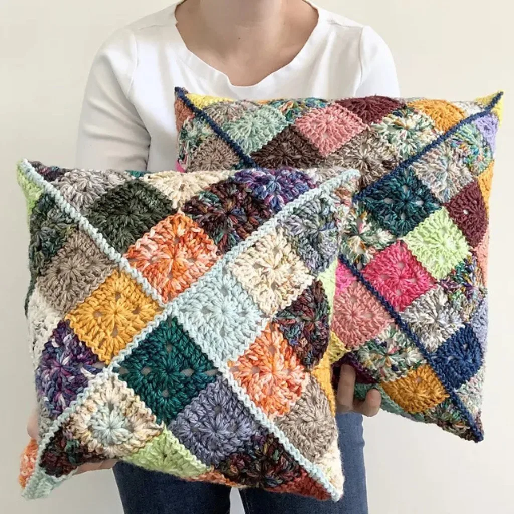 A women holding 2 crochet cusshions made with leftover yarns