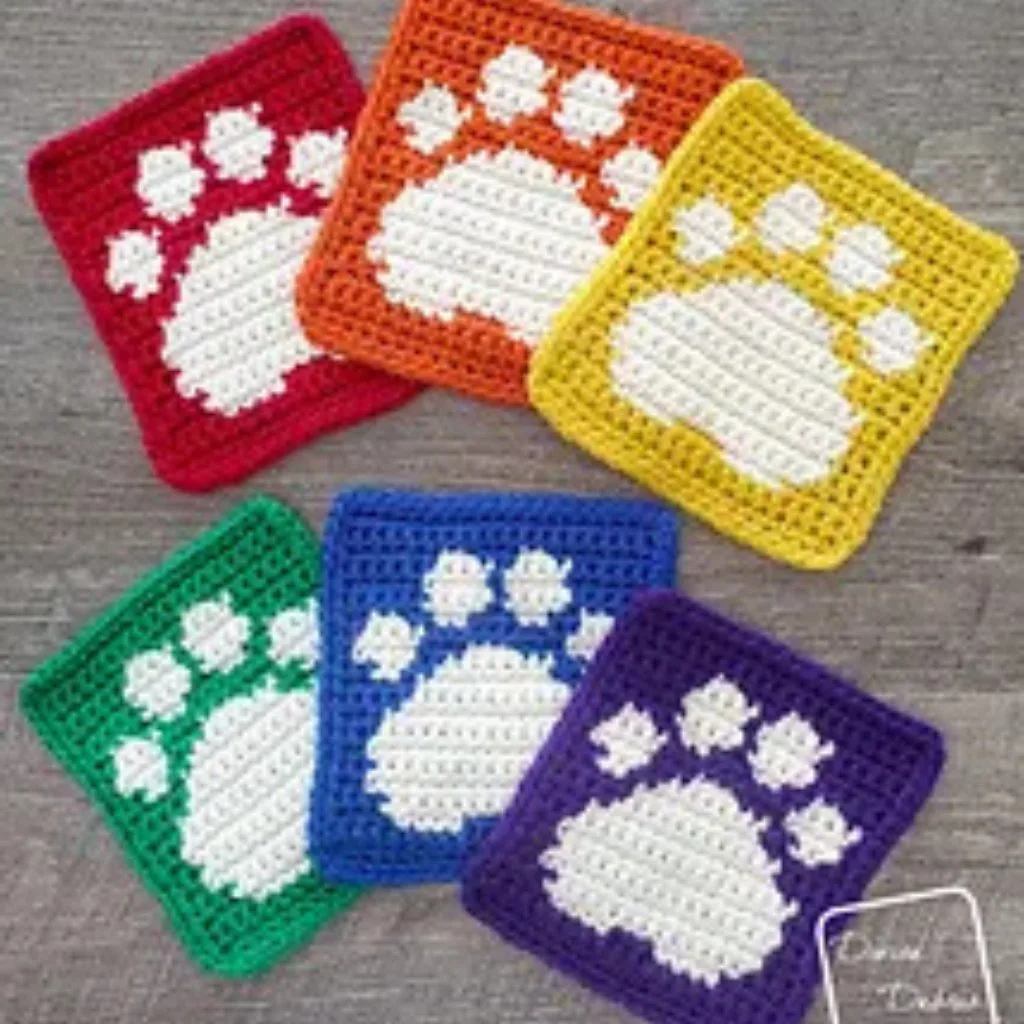 Six crochet coasters with paw prints.