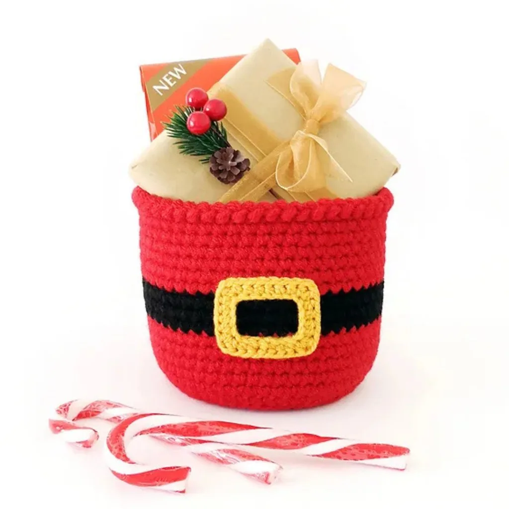 A crochet basket filled with gift boxes with two candy canes.