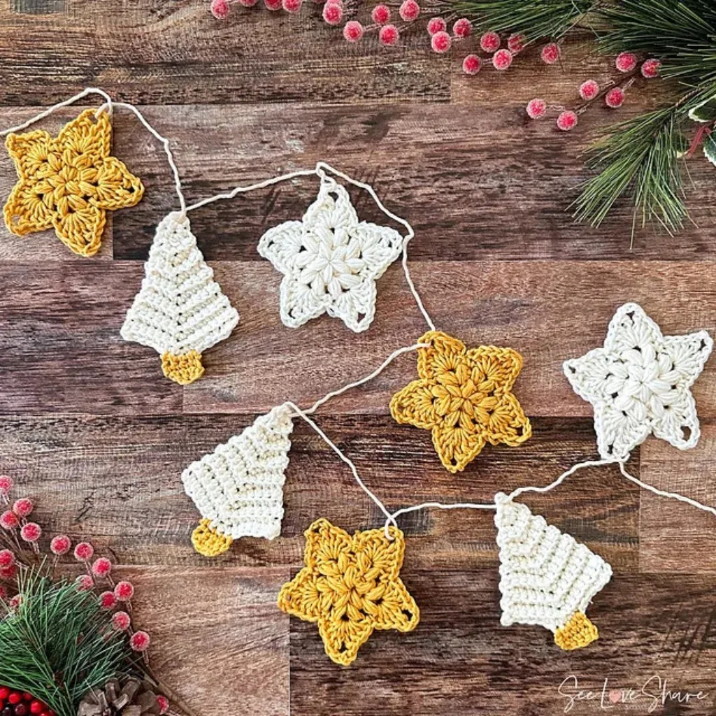 Crochet mini christmas trees and stars on a wooden surface and christmas picks.