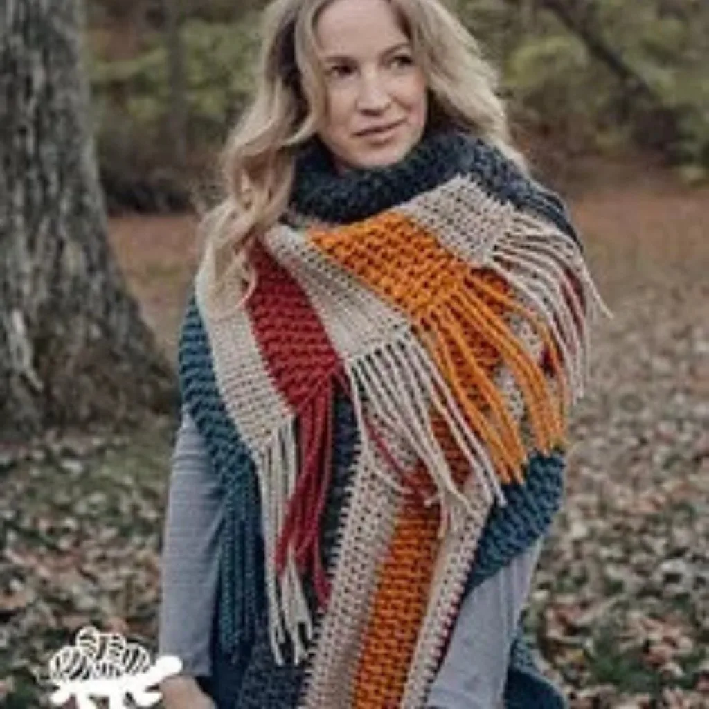 A women wearing a large colorful scarf with fringes.