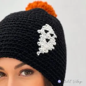 A close-up of a crochet hat featuring a ghost print design, perfect for Halloween.