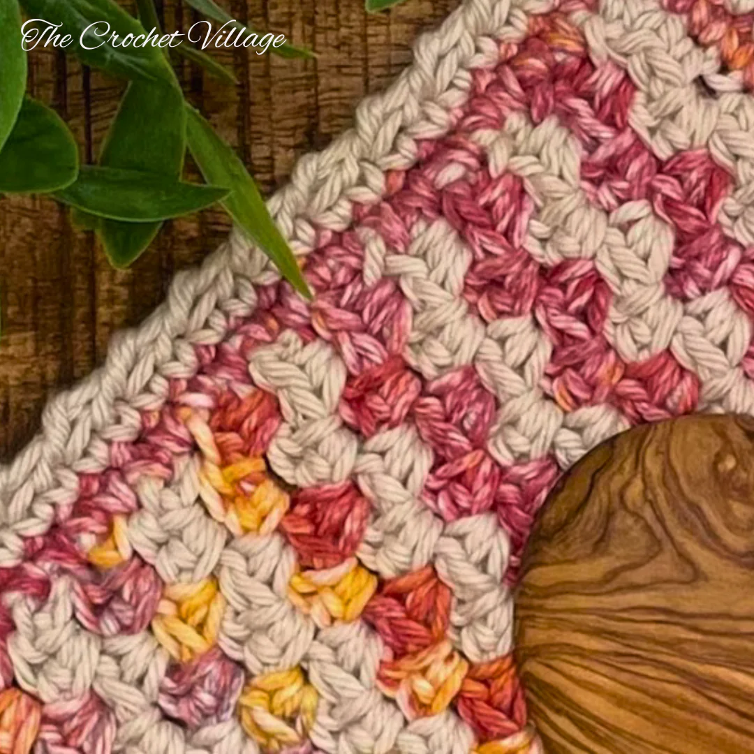 A close up of a colorful and textured crochet cloth.