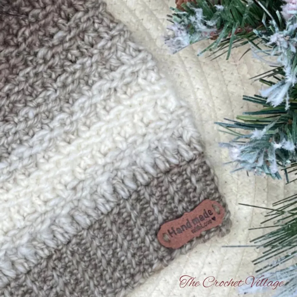 Close-up of a crochet hat ribbing with a leather tag, showcasing the detailed texture and neat stitches