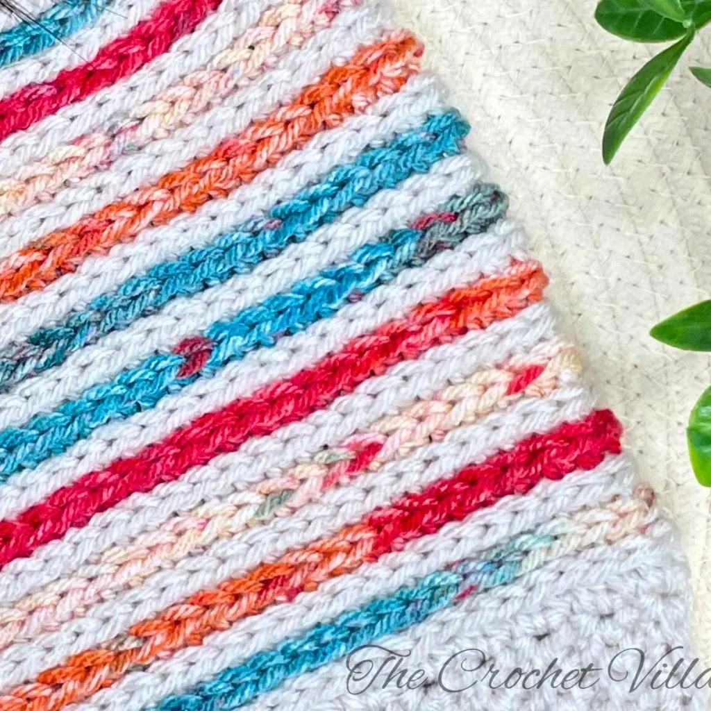 A vibrant striped crochet piece with bold and cheerful colors.