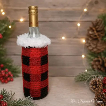 Wine bottle in a crochet bag with faux fur trim, featuring festive Christmas colors.