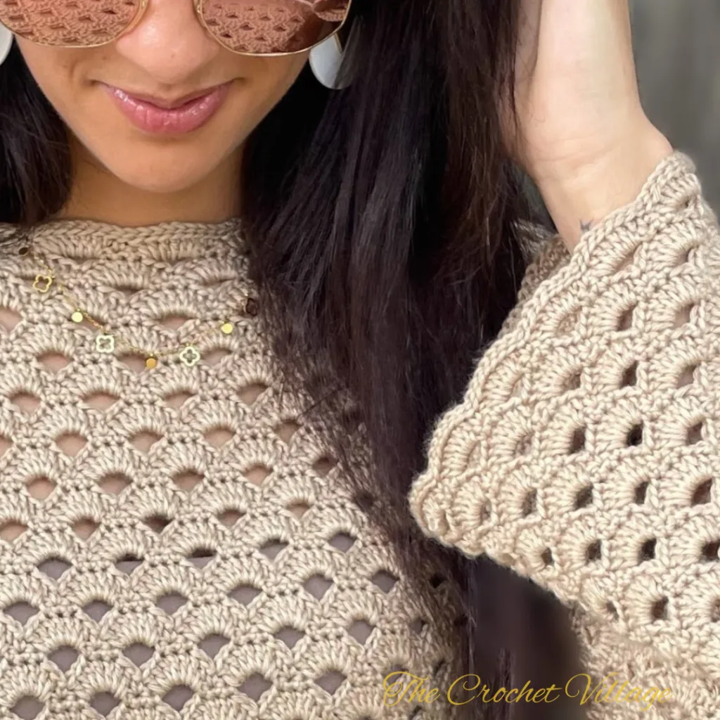 A close-up of the edging on a long-sleeve crochet top, showcasing the stitch details and smooth finish.