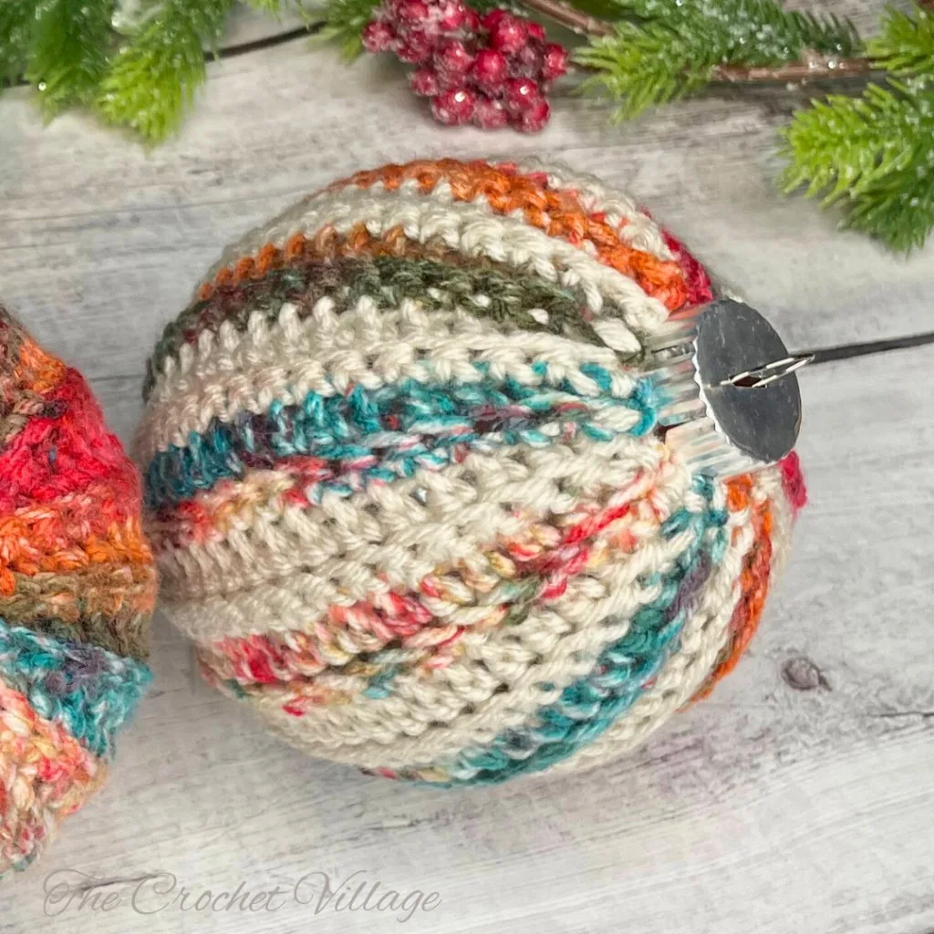 A colorful, handmade crochet bauble ornament, showcasing vibrant patterns and intricate details.