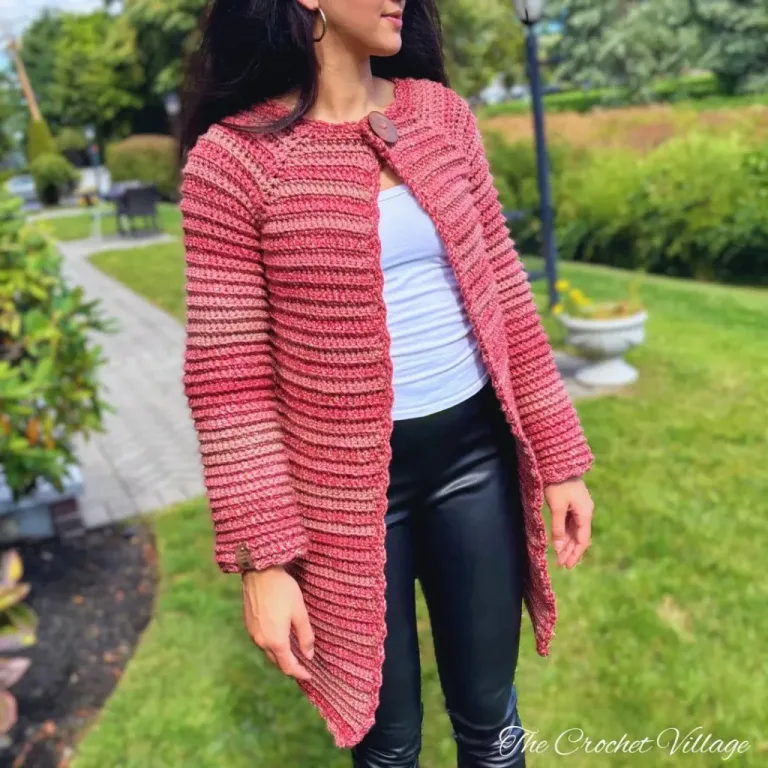 A young women wearing a long crocheted winter coat jacket.