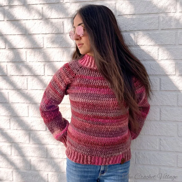 Woman wearing chestnut crochet raglan sweater in relaxed fit, showing drape and fit from front