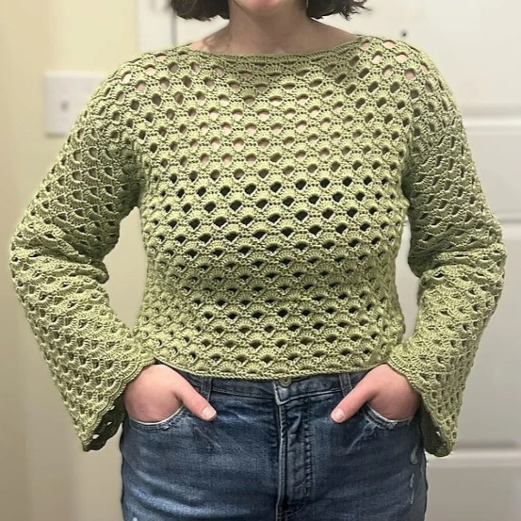 A plus size women wearing a simple lightweight crochets weater