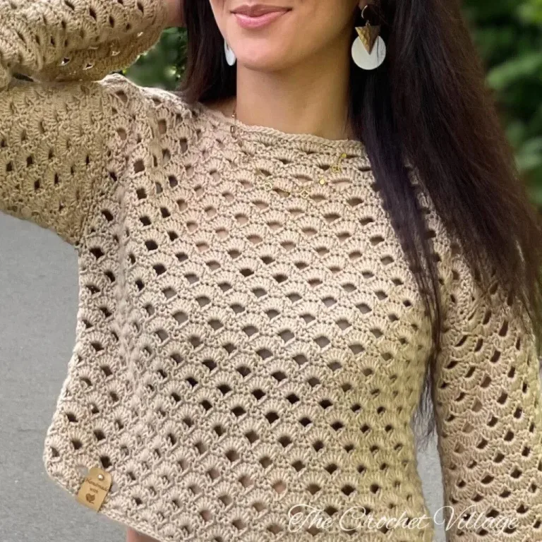 A girl wearing large earrings and a crochet sweater with a leather tag.