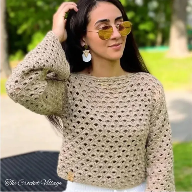 A women with glasses wearing a long sleeve lacy top