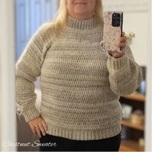 A woman taking a photo of herself wearing a simple crocheted winter sweater.
