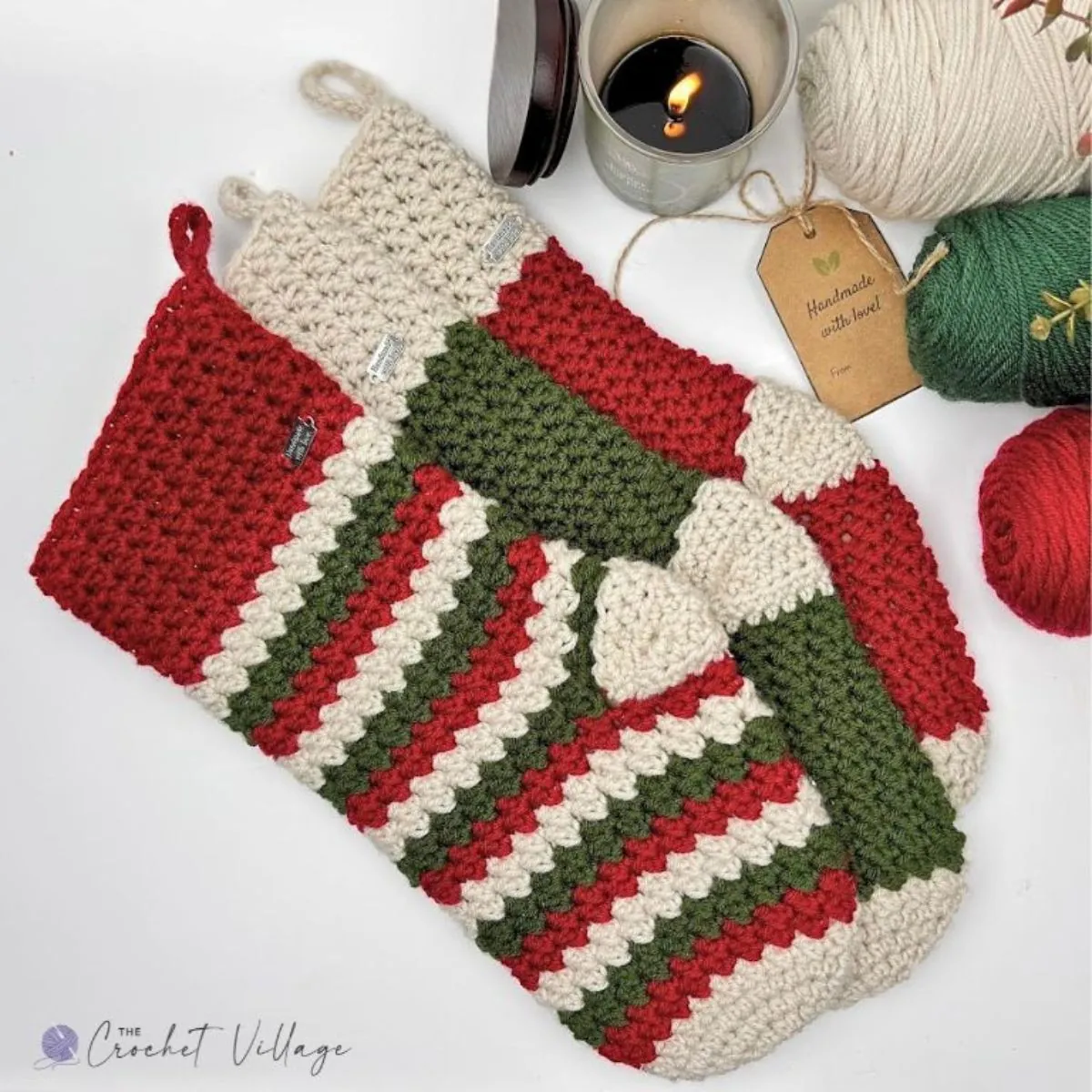 Three large crochet Christmas stockings in red, green and cream — striped and solid versions of the North Pole pattern