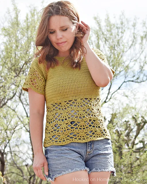 A young woman wearing a lacy and feminine crochet raglan style blouse