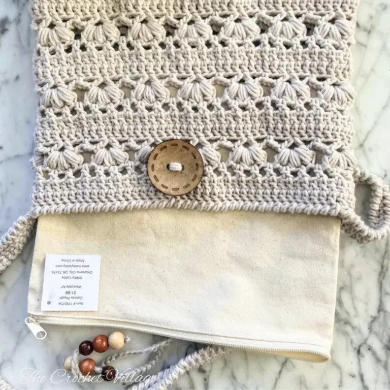 A premade canvas pouch with a zipper being inserted into a crochet bag to line it for added structure and durability.