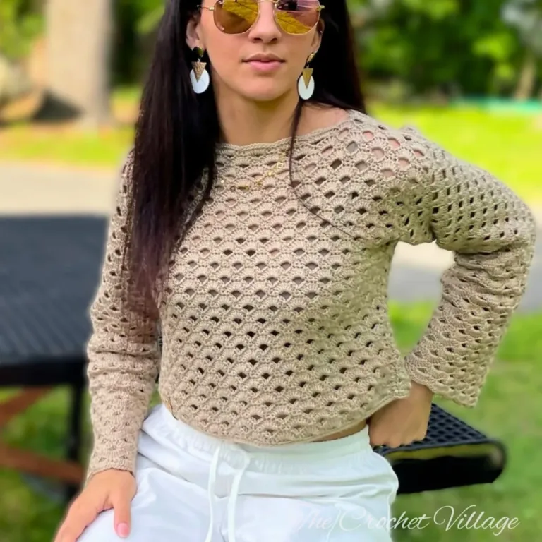 A women with glasses wearing a crochet long sleeve lacy crop top