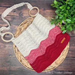 A stylish crocheted shoulder bag with a sturdy strap attached using wooden rings.