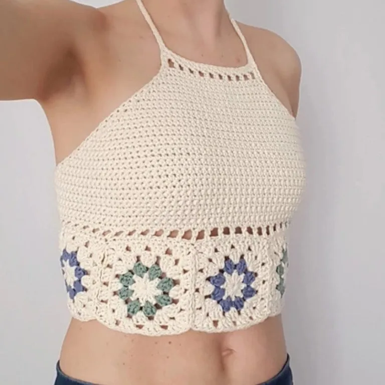 A person wearing a crochet halter top with granny squares, the perfect stylish and breezy summer top.