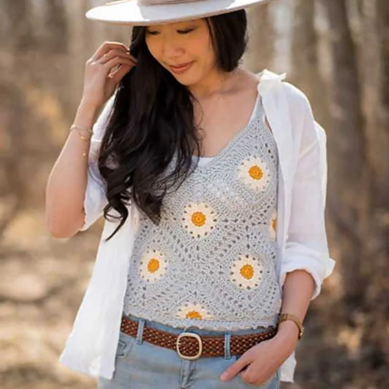 A young lady wearing a granny square tank top on a sunny day, enjoying the warm weather.