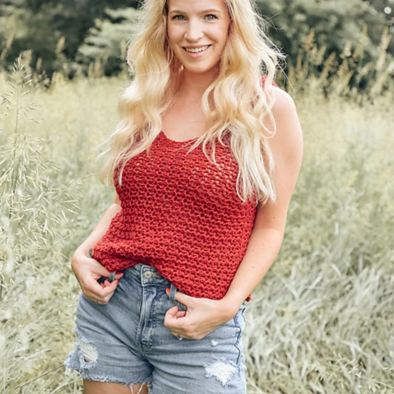 A woman wearing a gorgeous lacy crochet tank top, showcasing its intricate design and elegant style.