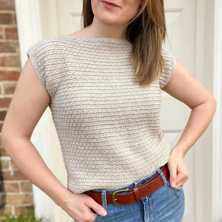 A woman wearing a simple and delicate crochet sleeveless tee, showcasing its lightweight and elegant design.