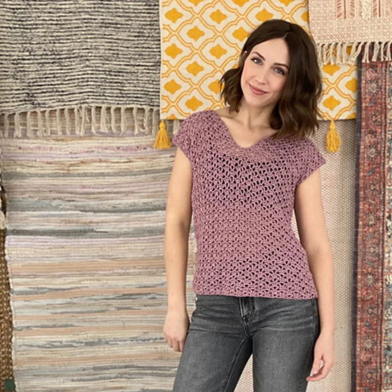 A woman wearing a simple crochet top, showcasing an elegant lacy design.