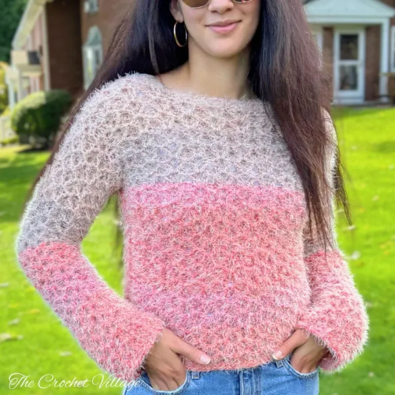 A young woman wearing a fuzzy, mohair crochet sweater showcasing the beautiful stitch and the snug fit, made with the Lilah Sweater crochet pattern.
