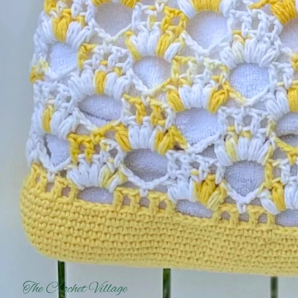 Crochet piece featuring puff stitches in shell and arc forms, creating a textured pattern.