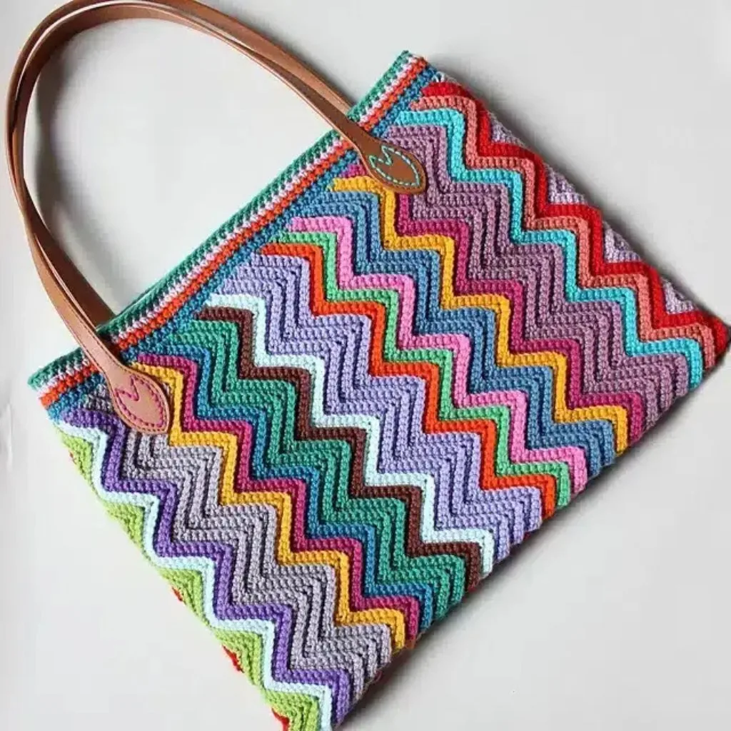 A colorful crochet zigzag shoulder bag featuring a chevron stitch design.