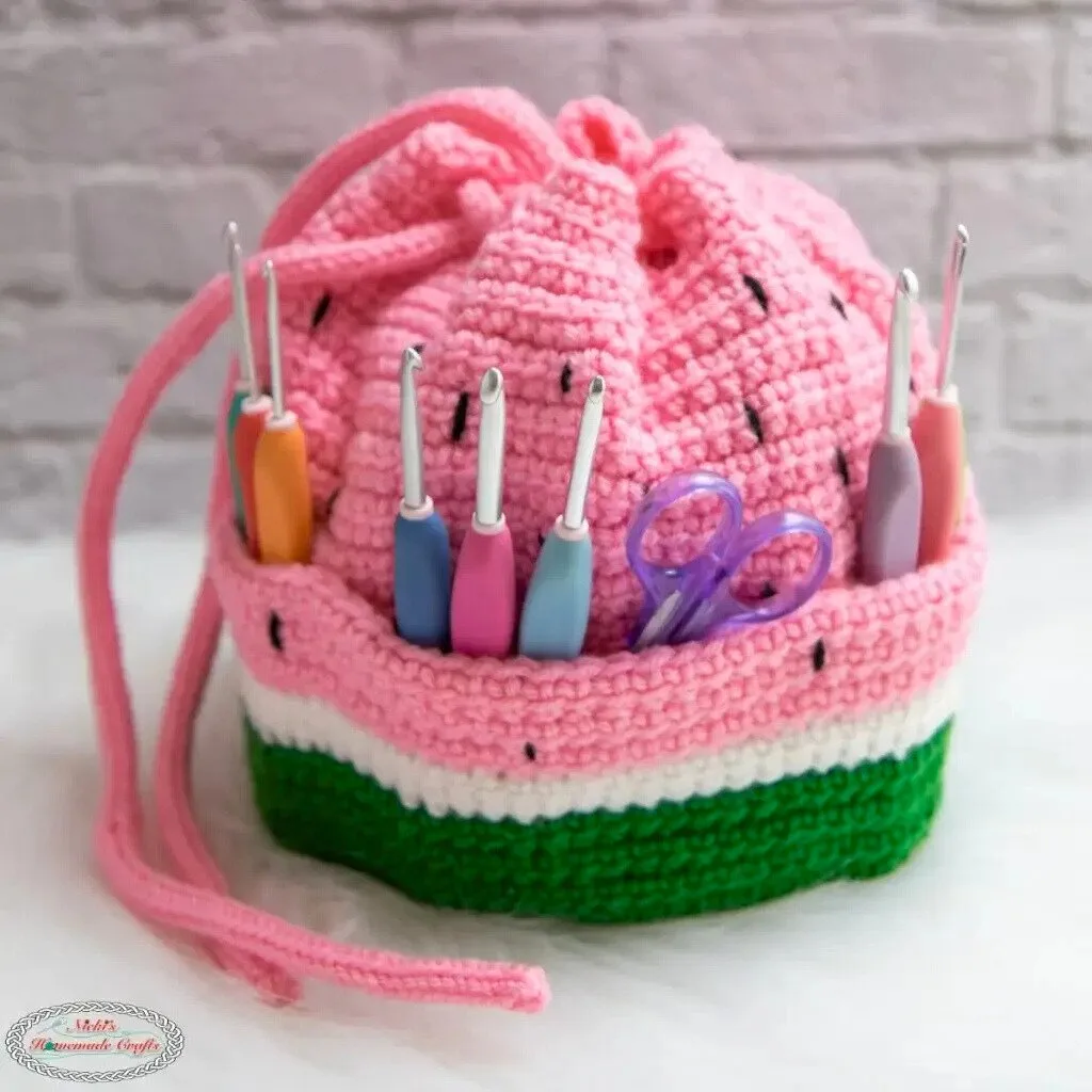 A crochet bag with multiple pockets, filled with crochet hooks and scissors.