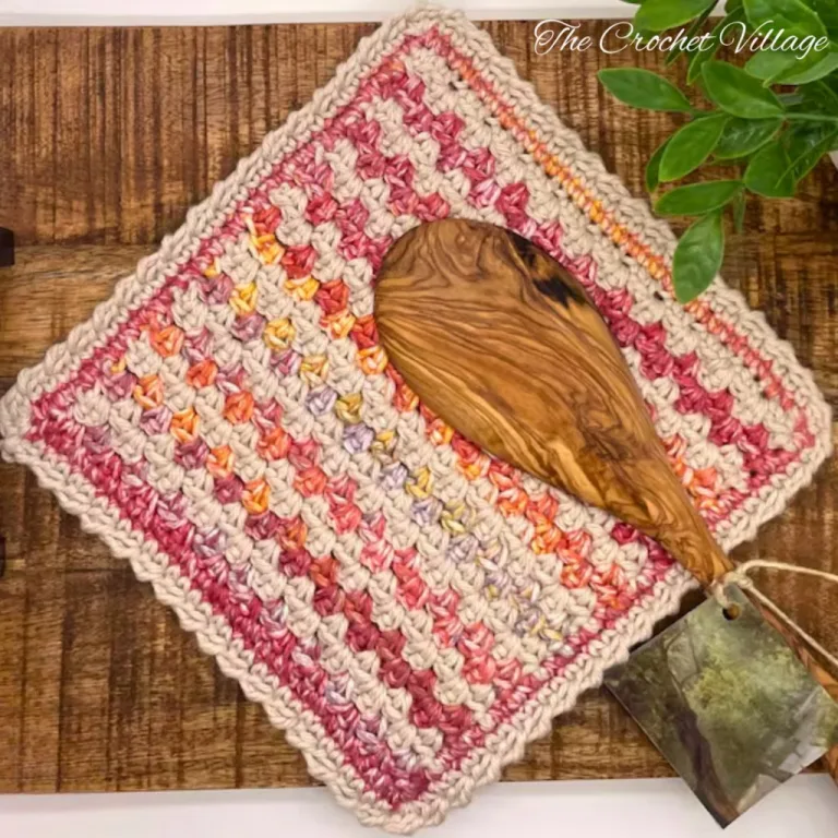 A multicolored textured crochet washcloth on wooden surface