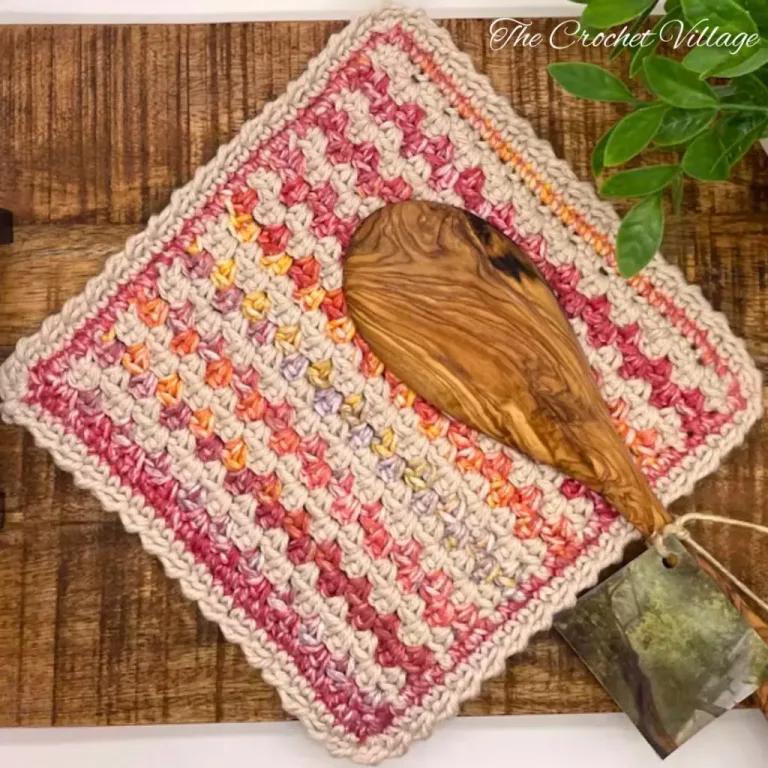 A multicolored textured crochet washcloth on wooden surface