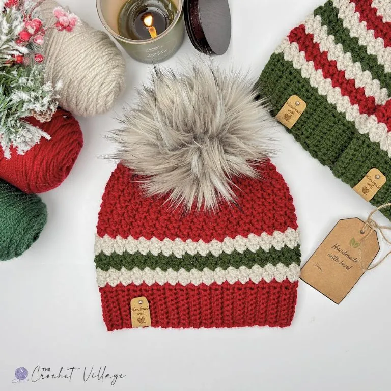 red crochet Christmas beanie with green and cream stripe band and faux fur pom pom - free crochet Christmas hat pattern