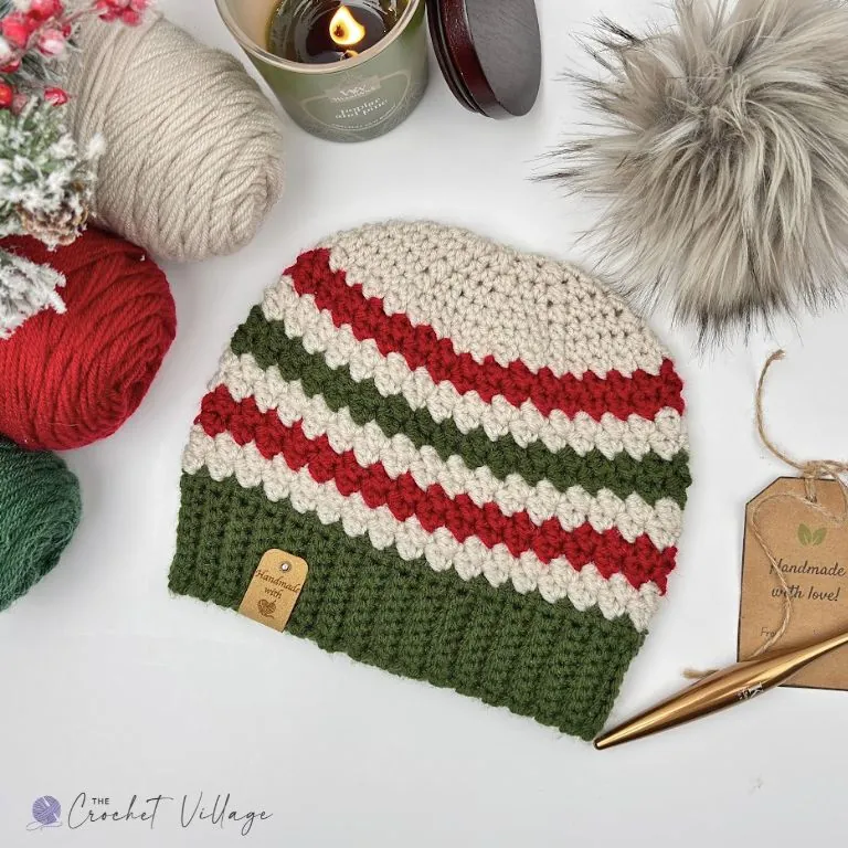crochet Christmas beanie laid flat showing red, green and cream stripes and a green ribbed brim - free crochet Christmas hat pattern