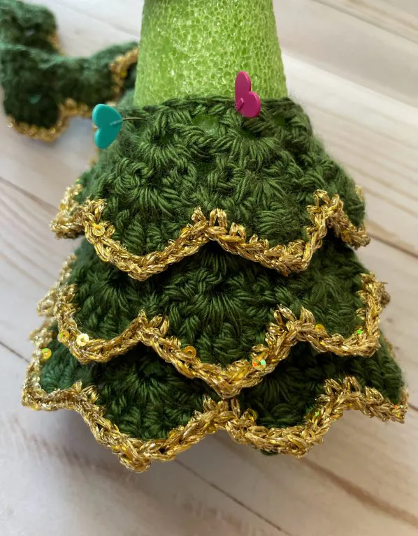 A close-up photo showing how to wrap the crochet piece around the foam cone to make Grandma's Christmas tree