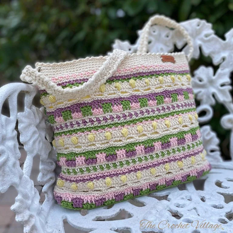 A close-up of a crochet scrap yarn bag, highlighting the vibrant mix of colors and intricate stitches used in the design.