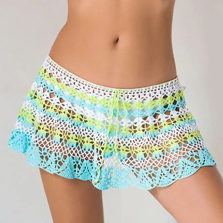 A person wearing a lacy mini crochet skirt as a beach cover-up, perfect for adding a touch of elegance to a summer look.