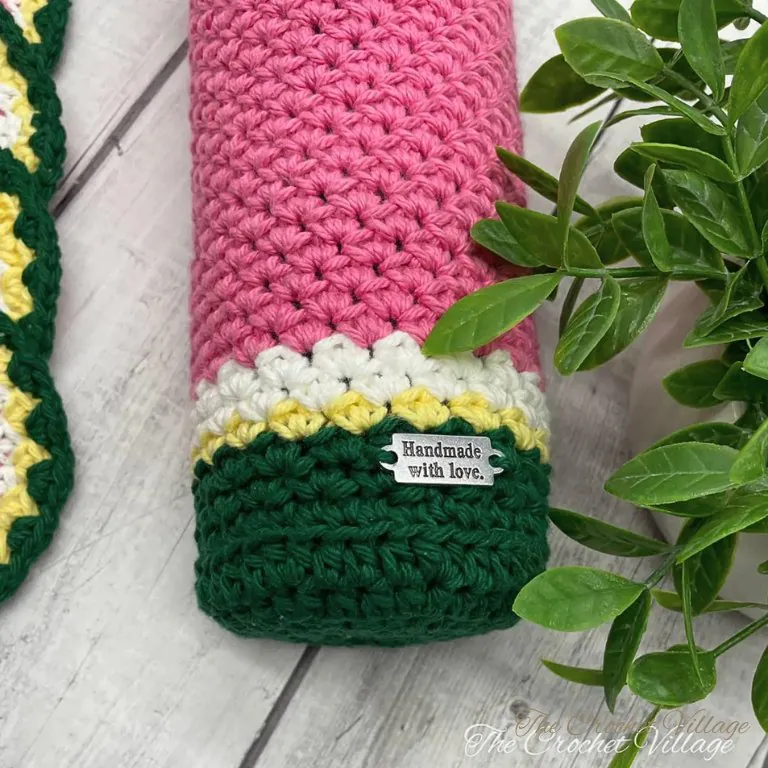 Flat lay of crochet watermelon wine bottle cover showing stitch detail and colorwork