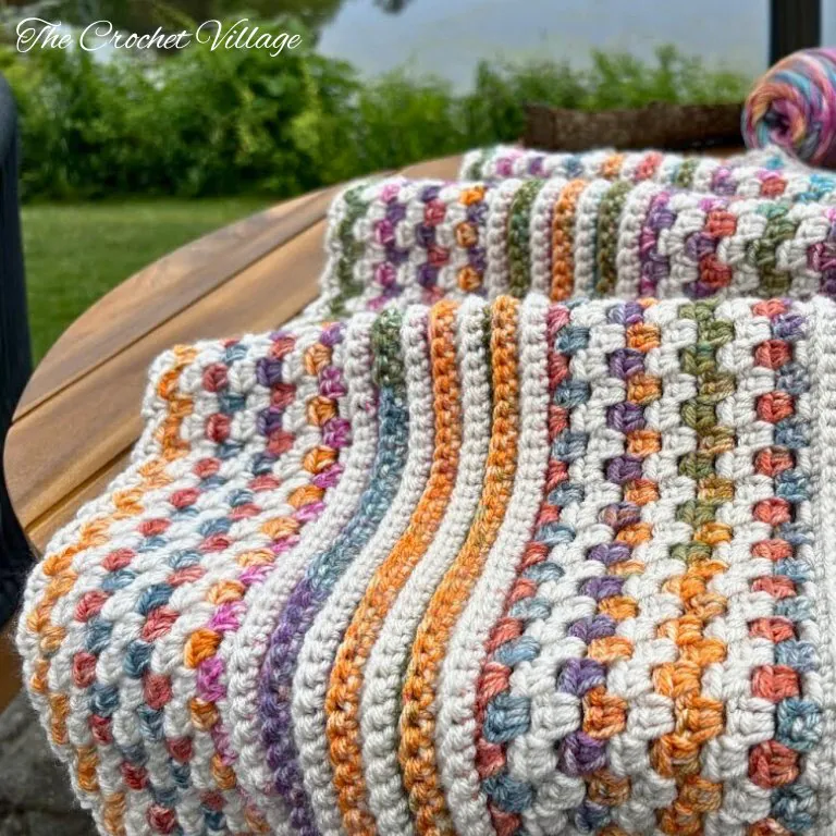 Close-up of a reversible crochet blanket featuring multicolor stripes, textured stitches, and a delicate edging – beginner-friendly and customizable crochet pattern.