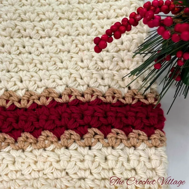 Close-up of a crochet washcloth decorated with festive Christmas picks.