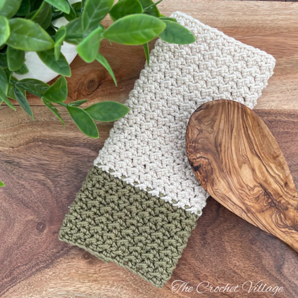 Autumn-themed crochet pot holder folded with wooden spoon for kitchen use