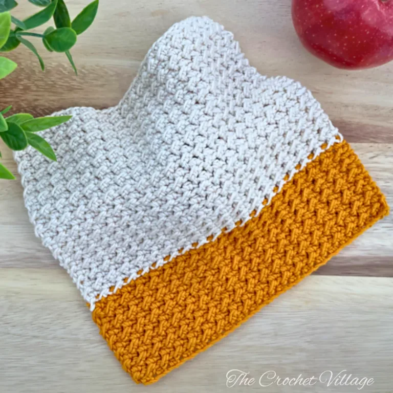 Handmade crochet washcloth/pot holder/ hot pad in autumn Thanksgiving colors displayed on rustic wooden surface