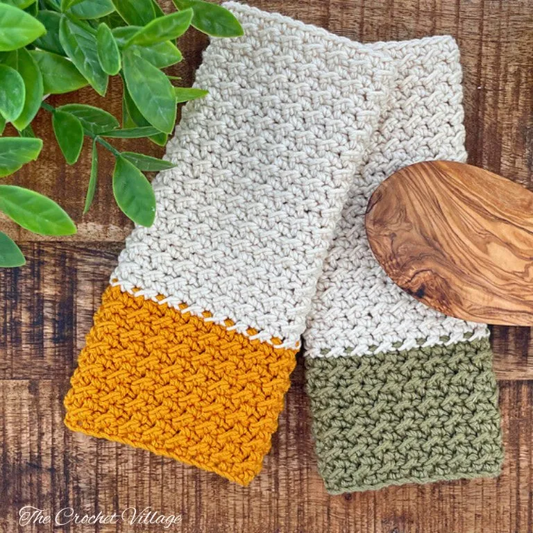 Two handmade crochet wash cloths and pot holders in a kitchen setting, using cotton yarn