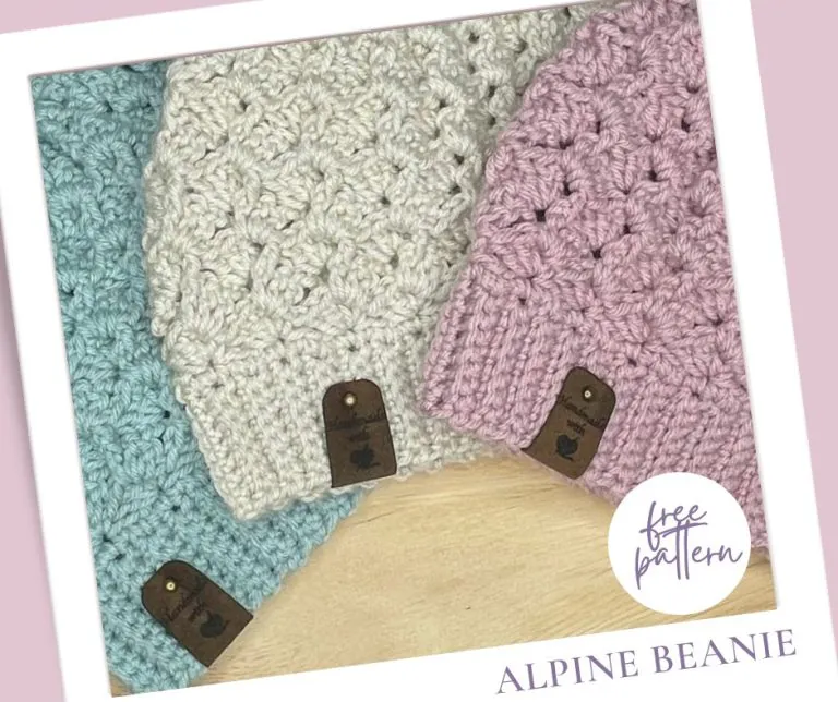 Close-up of three Alpine crochet hats in light blue, light pink, and beige showing ribbed texture detail