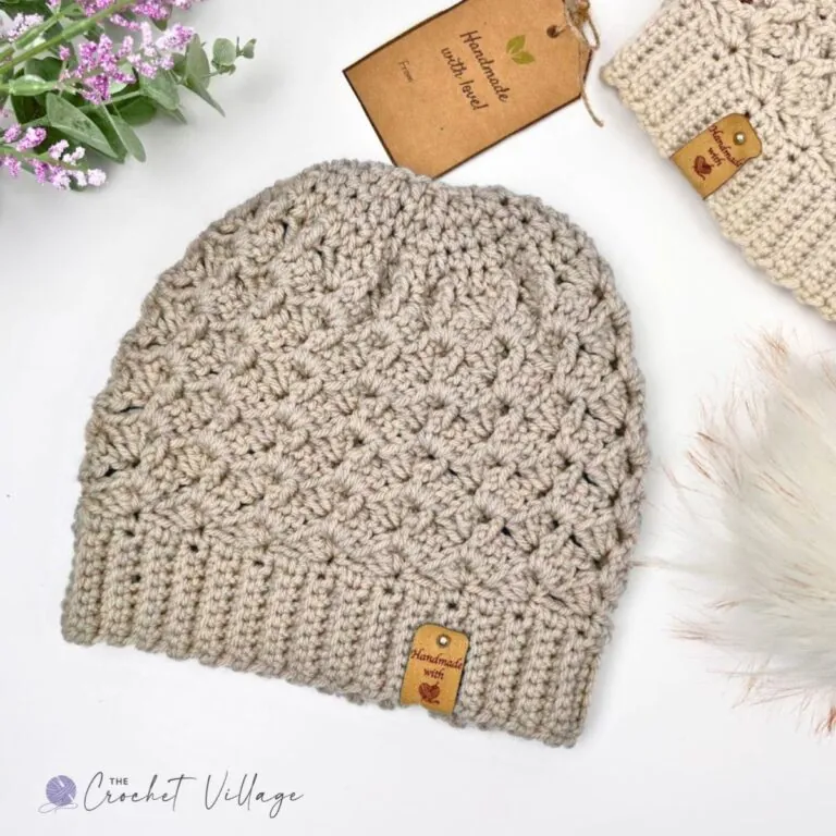 Alpine Hat crochet beanie in ivory with a ribbed brim and textured stitch pattern, styled flat lay with a handmade gift tag