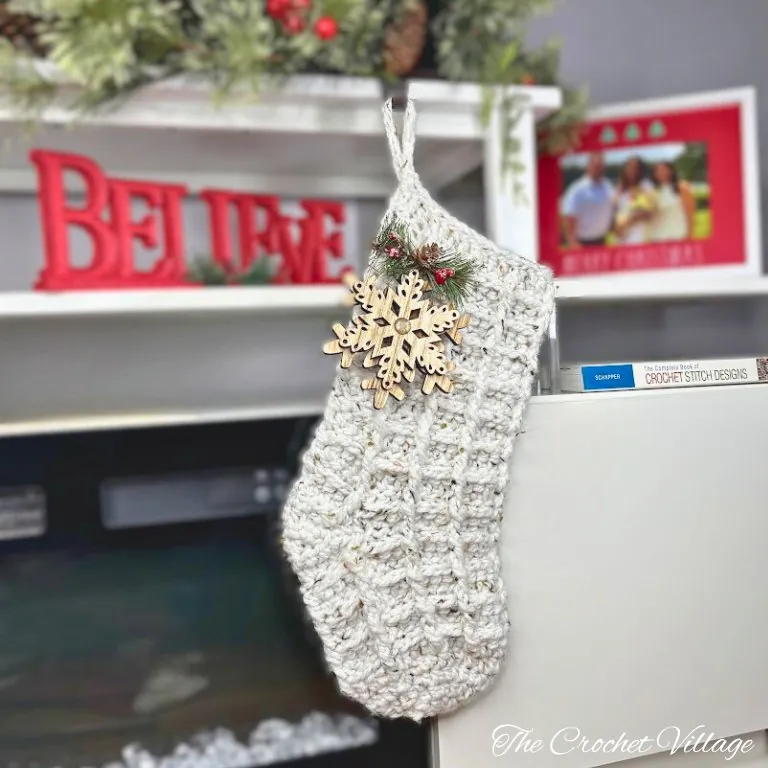 Large chunky crochet Christmas stocking with waffle stitch texture hanging by fireplace mantel
