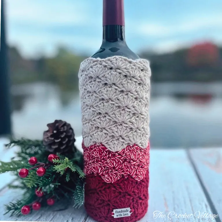 Burgundy crochet wine bottle cover on table with Christmas decor